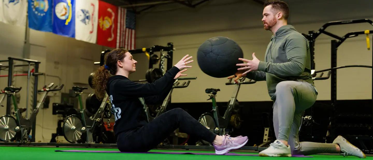 Two people performing partner core exercises.