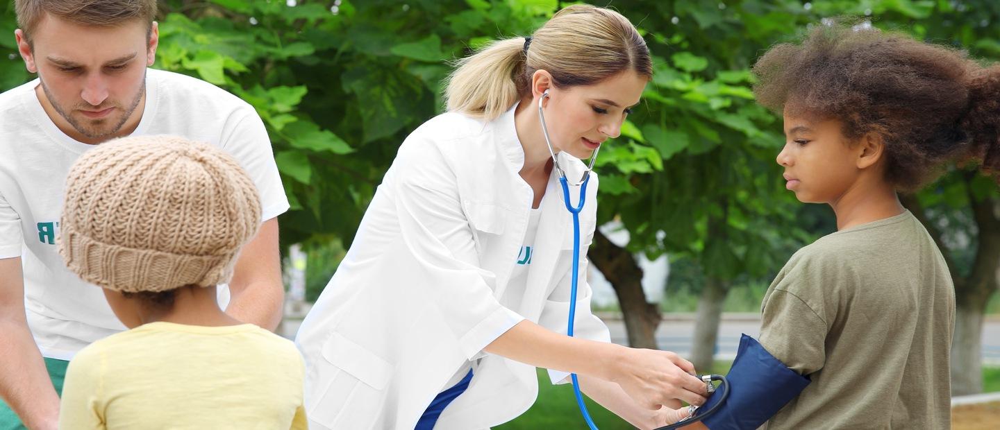 Medical professionals taking children's blood pressure